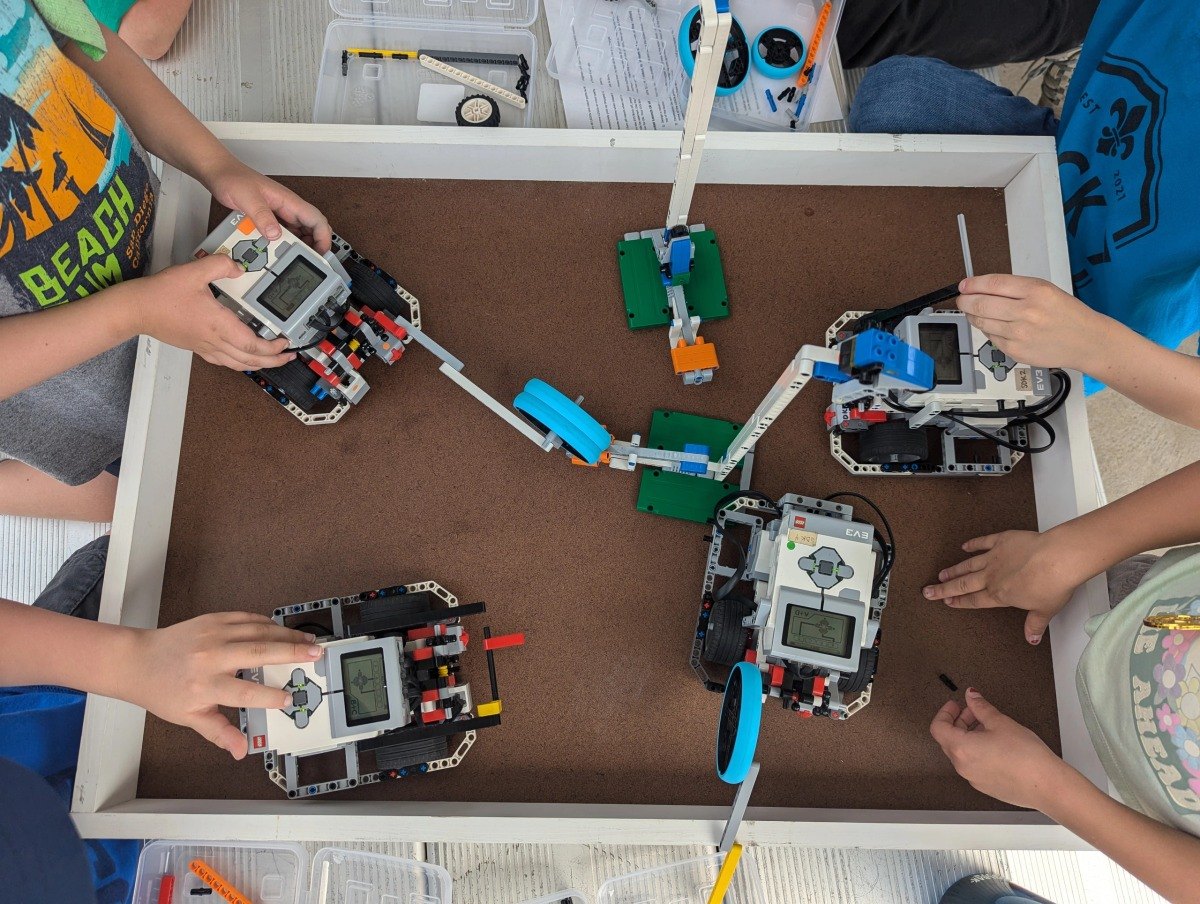 Students collaborating on LEGO robots at Code N Bots